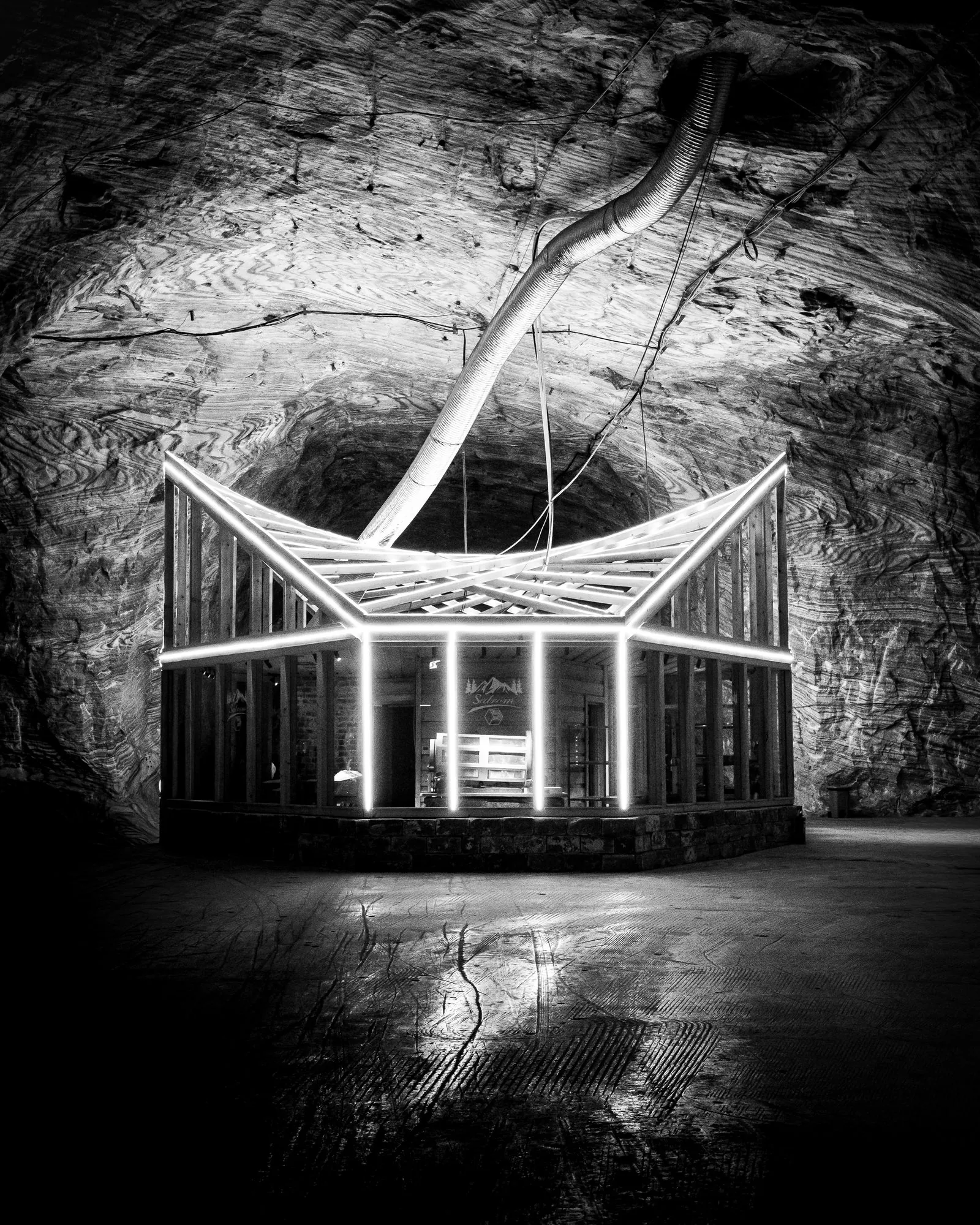 Black-and-white photograph of an illuminated structure inside the Târgu Ocna salt mine