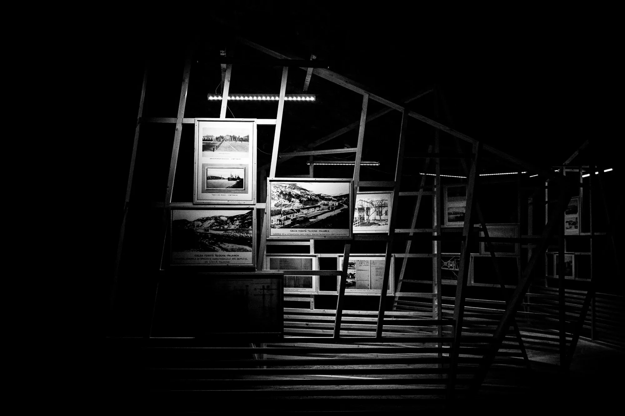 Wide black-and-white study of a geometric exhibition structure inside the Târgu Ocna salt mine