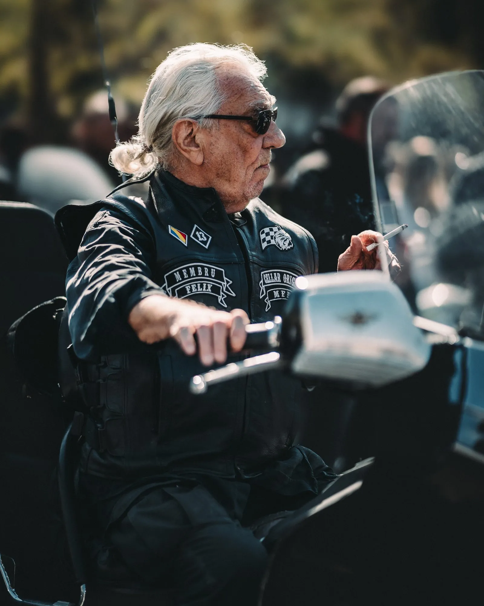Older motorcycle rider in sunglasses seated on a motorcycle