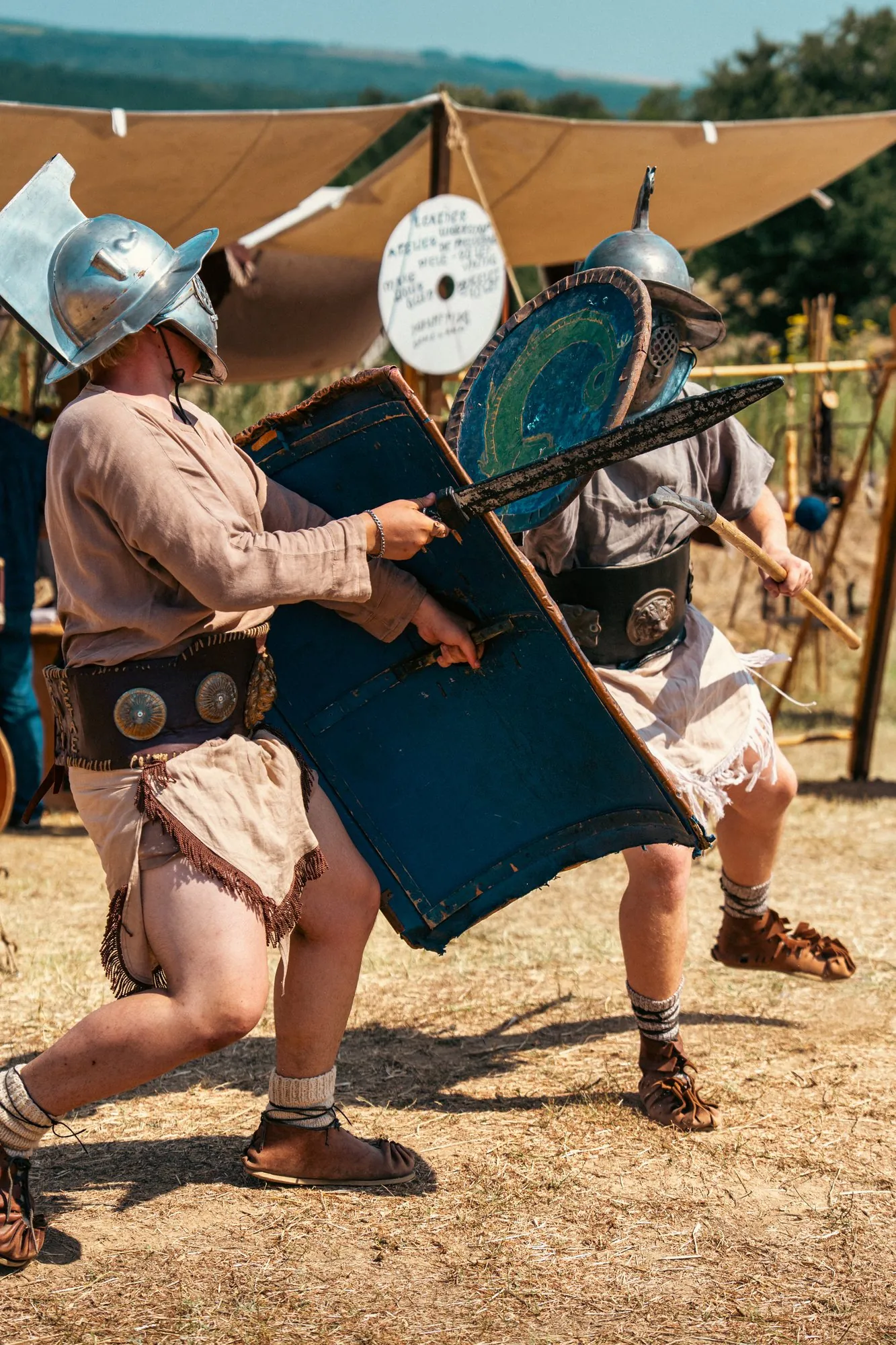 Two historical performers sparring with shields and weapons