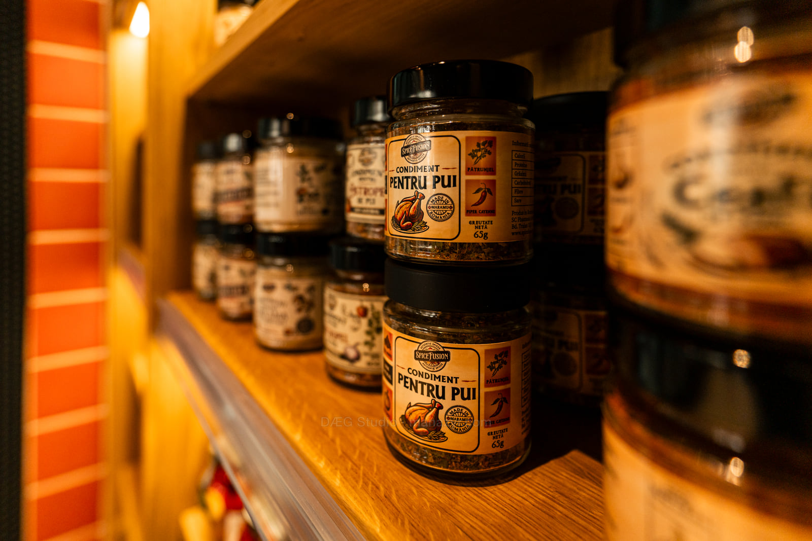 Prim-plan cu un borcan de condiment pe raft, în lumina caldă a magazinului.