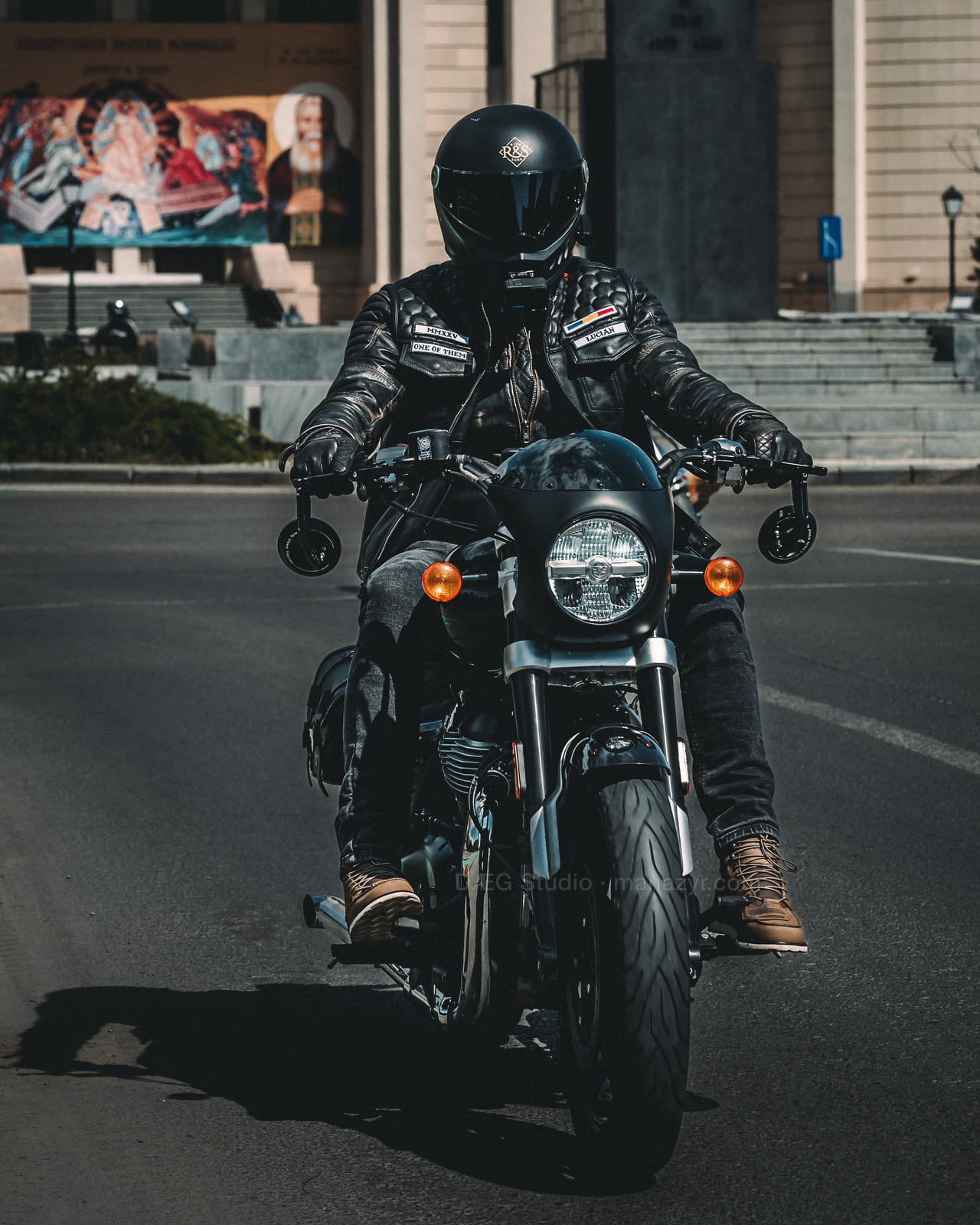 Front view of a fully helmeted rider on a black motorcycle.