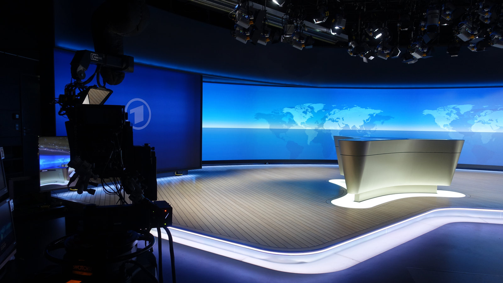 Tagesschau virtual television studio with broadcast camera, lighting grid and curved video wall