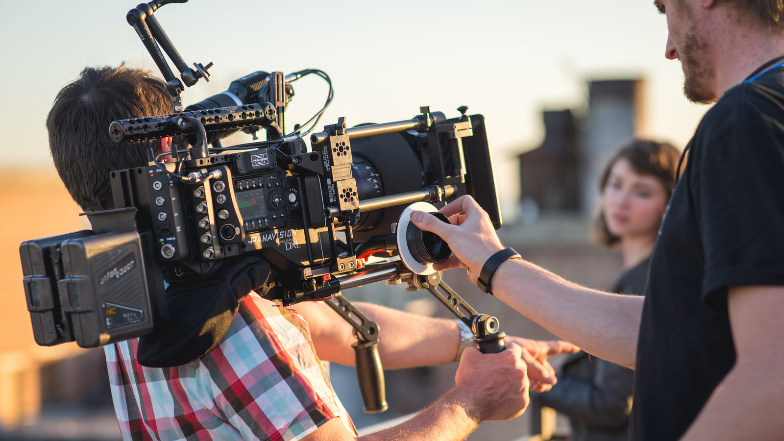A focus puller adjusting a Panavision cinema camera; this is operating context, not Fujifilm, ETERNA 55 or GF19–35 hardware.